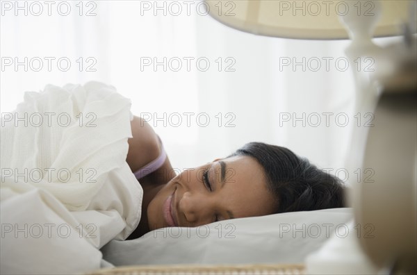 Mixed race woman sleeping in bed