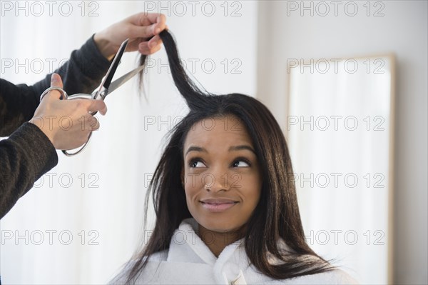 Mixed race woman getting hair cut
