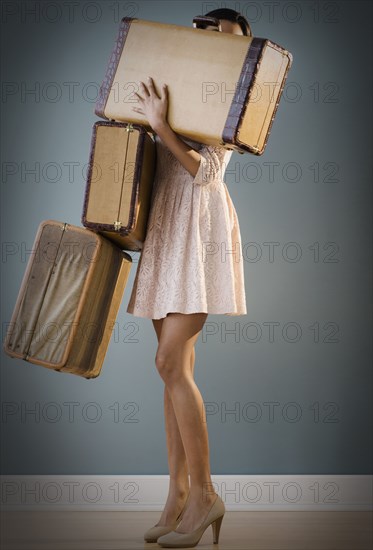 Mixed race woman carrying suitcases