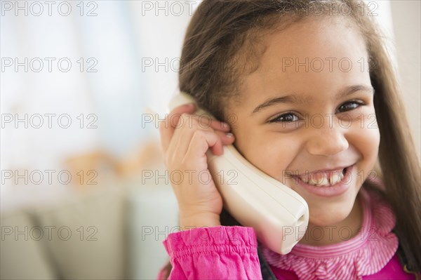 Hispanic girl talking on telephone