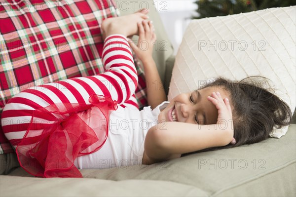 Hispanic girl laying on sofa