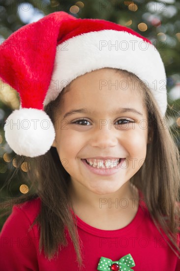 Hispanic girl wearing Santa hat