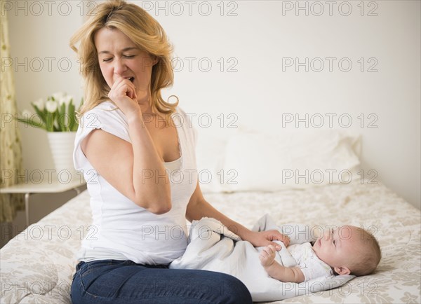 Yawning Caucasian mother with baby
