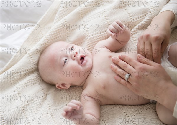 Caucasian mother changing baby's diaper