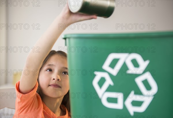 Mixed race girl recycling can