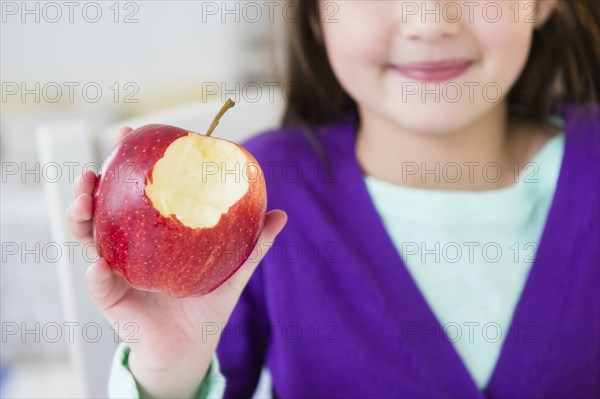 Mixed race girl eating apple