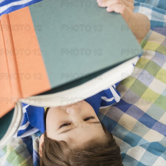 Hispanic boy reading on bed