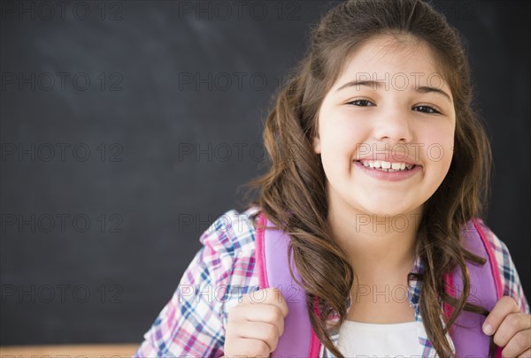 Hispanic girl smiling in classroom