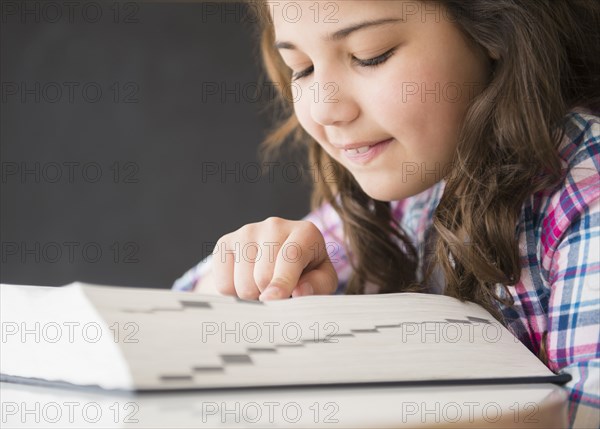 Hispanic girl looking up word in dictionary