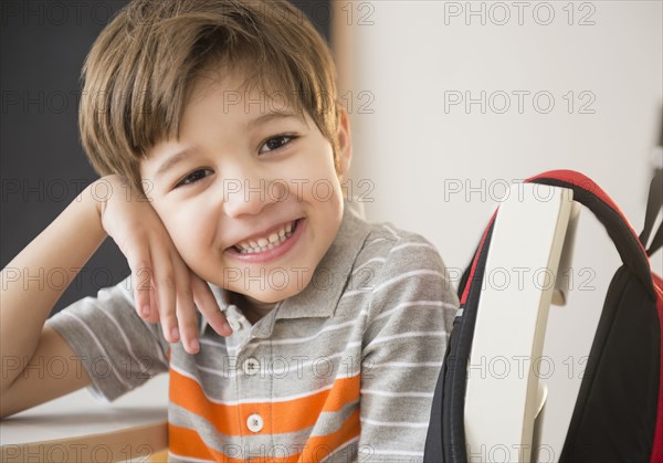 Hispanic boy smiling at desk