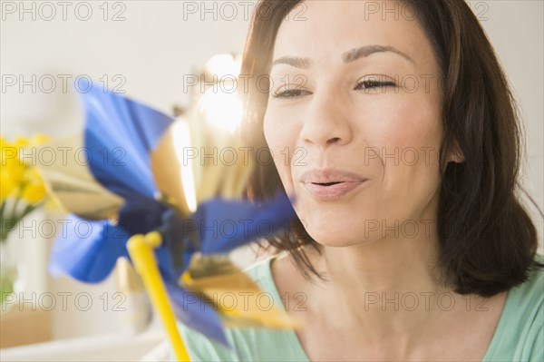 Caucasian woman blowing pinwheel