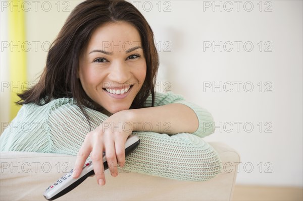 Caucasian woman watching television on sofa