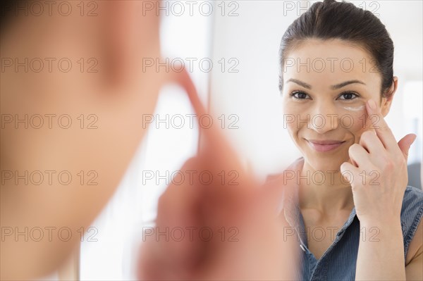Caucasian woman moisturizing her face