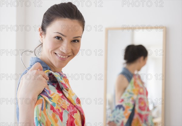 Caucasian woman trying on clothes in store