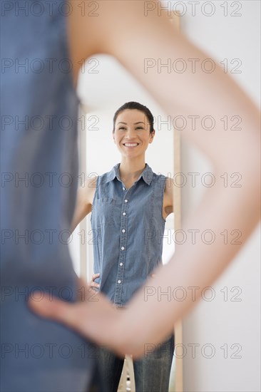 Caucasian woman admiring herself in mirror