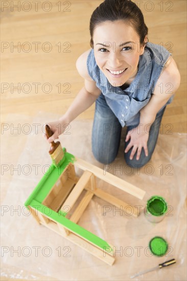 Caucasian woman painting stool