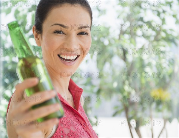 Caucasian woman holding bottle of beer