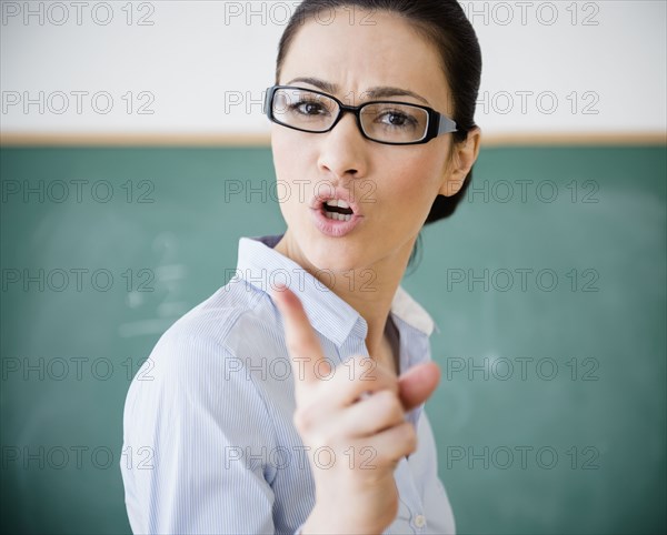 Caucasian teacher scolding in classroom