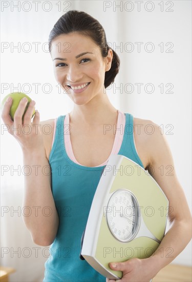 Caucasian holding apple and scale