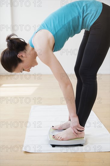 Caucasian woman weighing herself