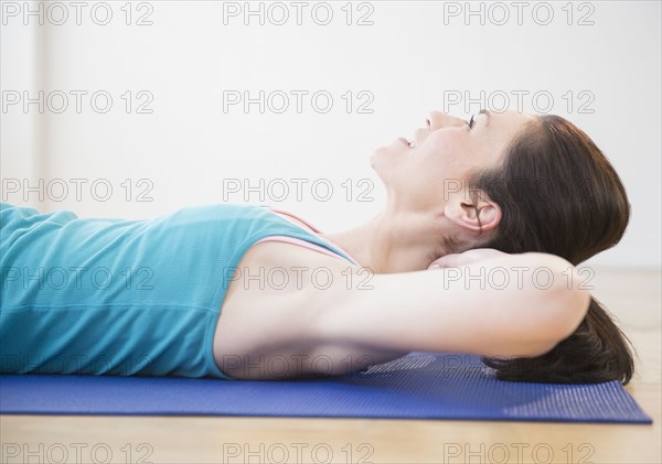 Caucasian woman laying on yoga mat