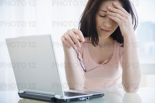 Frustrated Caucasian woman using laptop