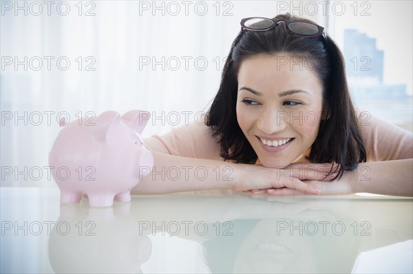 Caucasian woman examining piggy bank