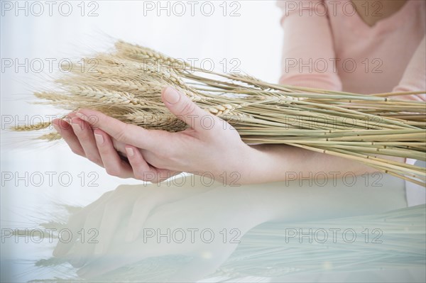 Caucasian woman holding stalks of wheat