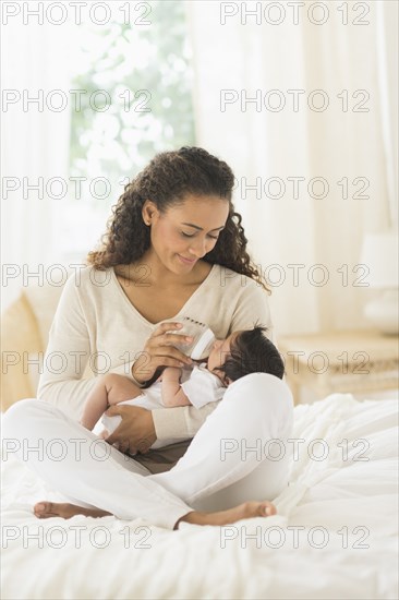 Hispanic mother bottle feeding infant son