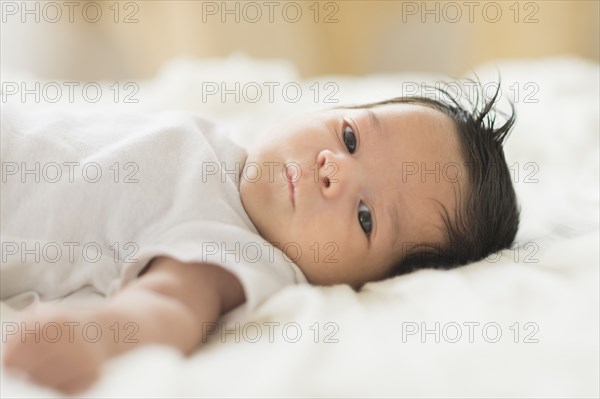 Hispanic infant laying on blanket