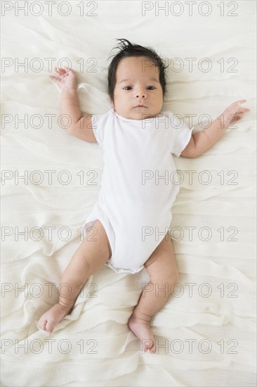 Hispanic infant laying on blanket