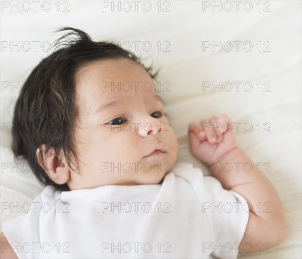 Hispanic infant laying on blanket