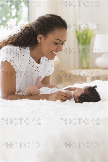 Hispanic mother playing with infant