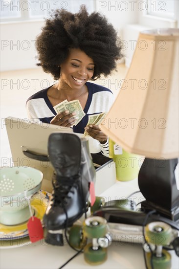 Mixed race woman counting money from yard sale