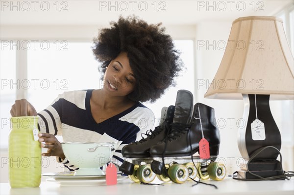 Mixed race woman putting price tag on items