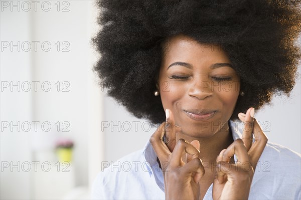 Mixed race woman crossing her fingers