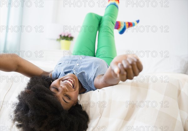 Mixed race woman smiling on bed
