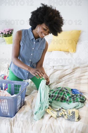 Mixed race woman folding laundry