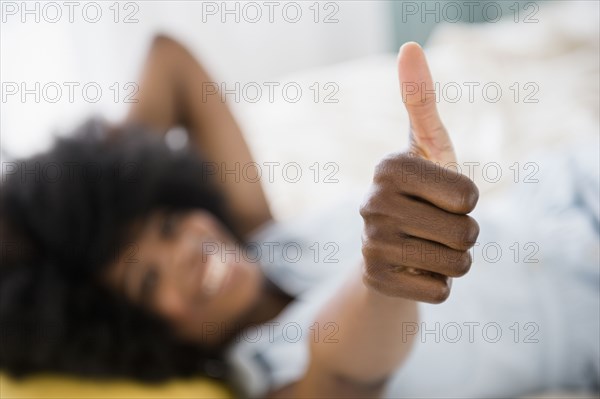 Mixed race woman giving thumbs up