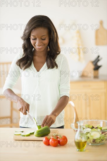 Black woman chopping vegetables in kitchen