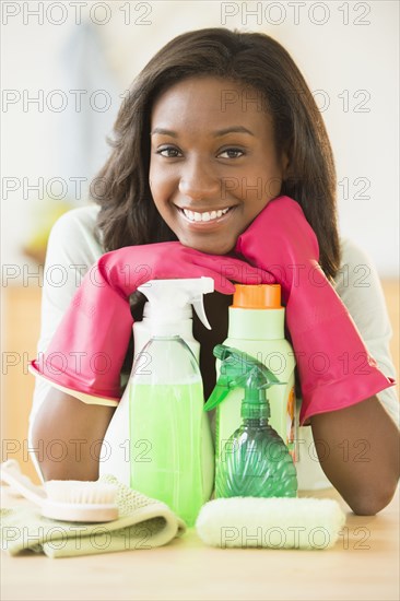 Black woman smiling with cleaning products