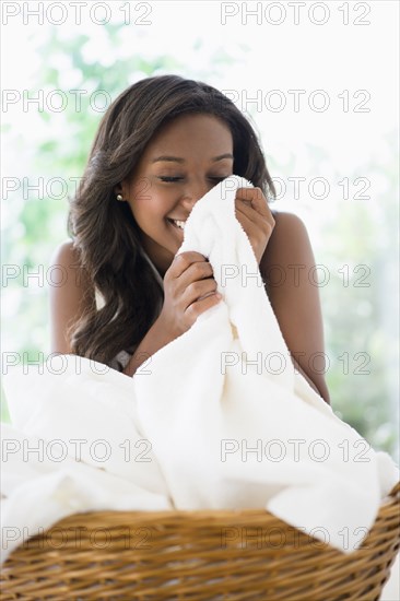 Black woman smelling clean towels