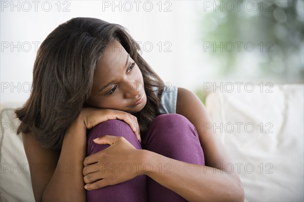 Black woman hugging her knees