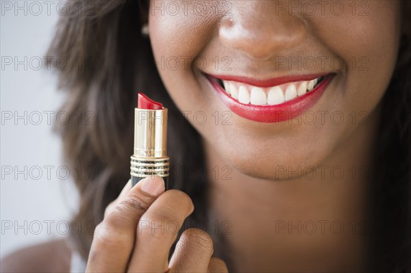 Black woman holding lipstick