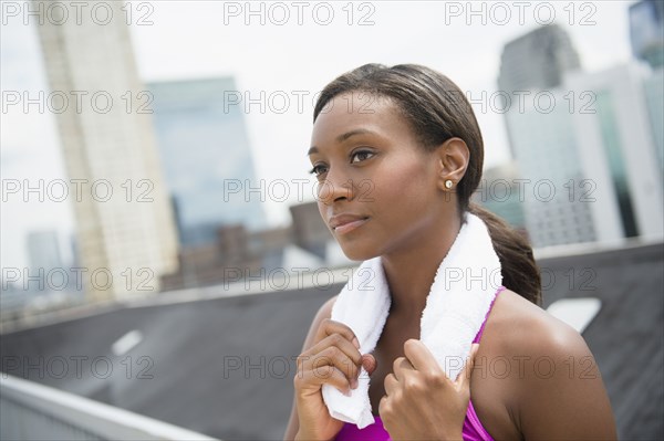 Black runner with towel around neck on city street