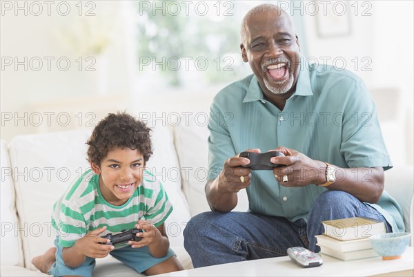 Boy playing video games with grandfather