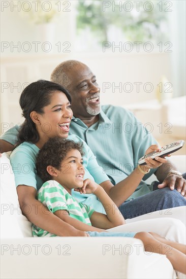 Three generations of family watching tv