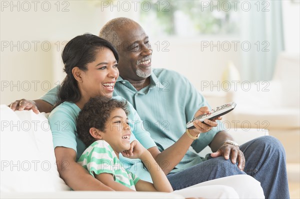 Three generations of family watching tv