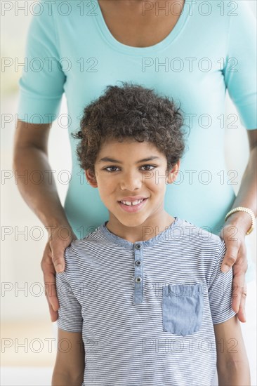 Smiling boy standing with mother