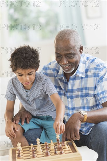 Boy playing chess with grandfather